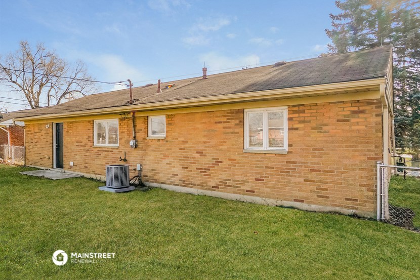 a small brick house with a yard and grass