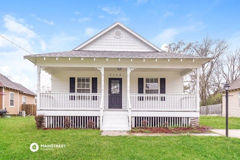 a white house with a front porch and a black door