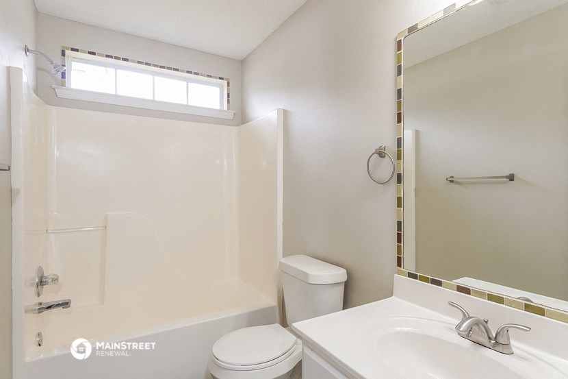 a bathroom with a sink toilet and a mirror