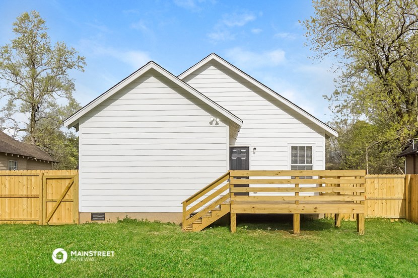 a backyard with a wooden fence and a house
