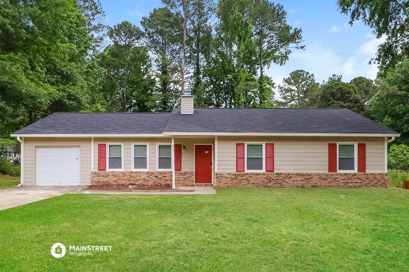 the front of a house with a lawn and a red door