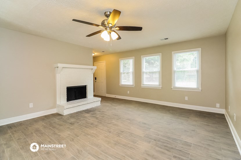 the living room with fireplace and ceiling fan