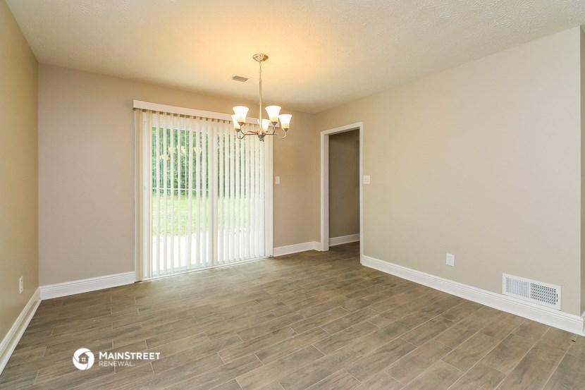 the living room and dining room of an empty house