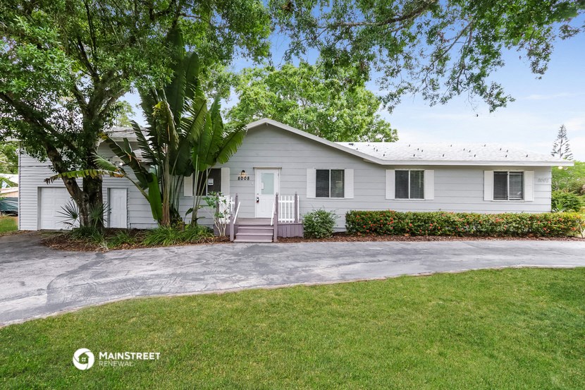a white house with a tree in front of it