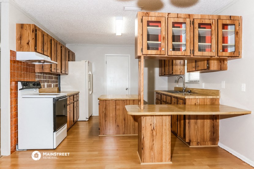 a kitchen with wooden cabinets and appliances and a counter top