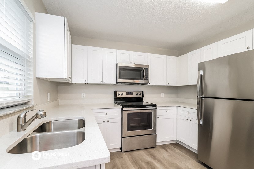 a kitchen with white cabinets and stainless steel appliances