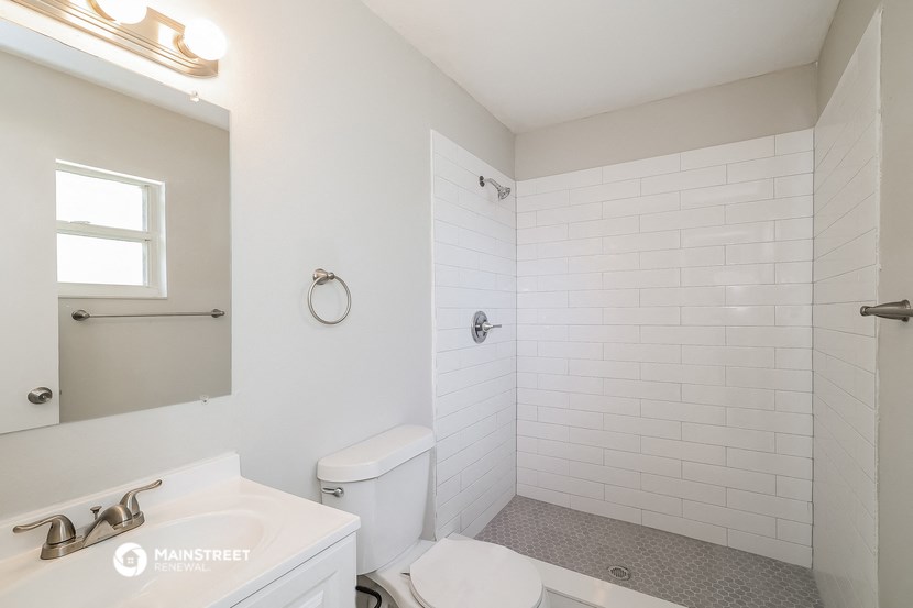 a bathroom with a toilet and a sink and a shower