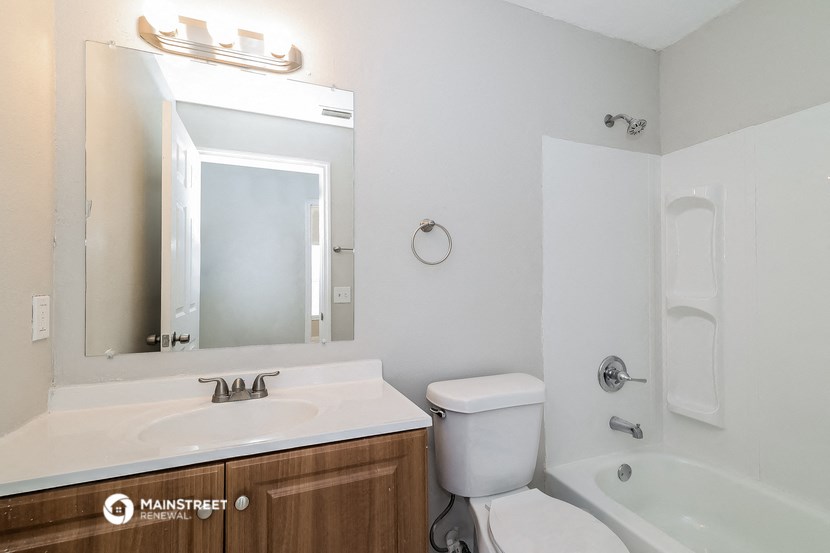 a bathroom with a sink toilet and mirror and a bath tub