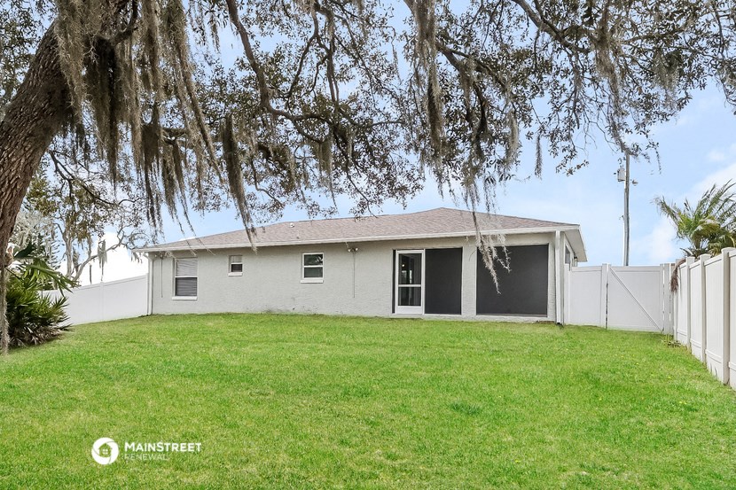 a small white house with a yard and a tree