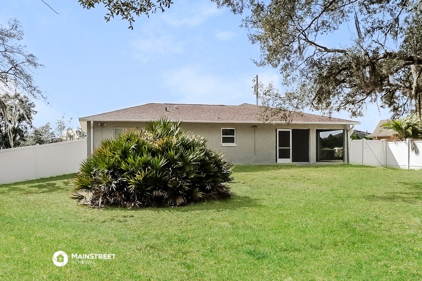 a home with a grass yard and a white fence