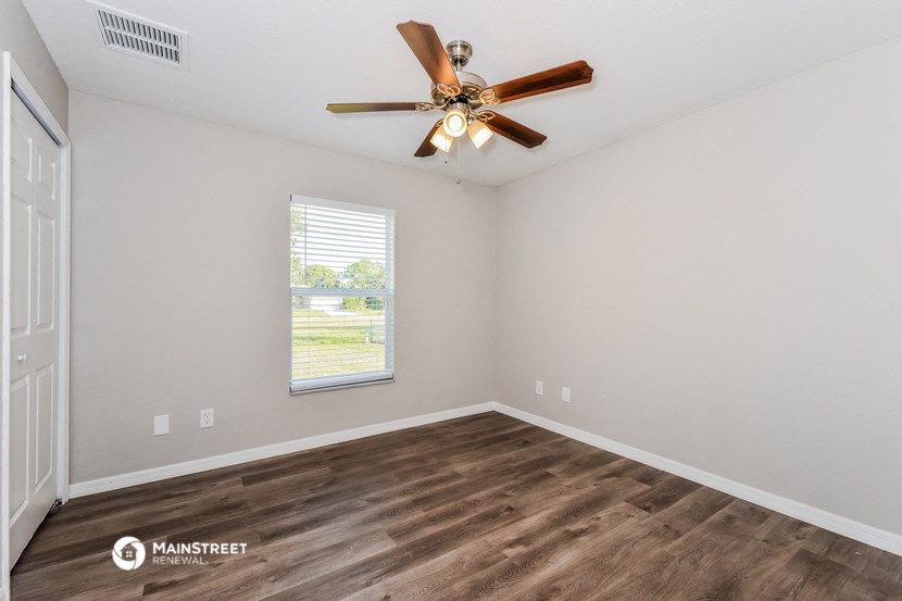the great room with ceiling fan and wood flooring