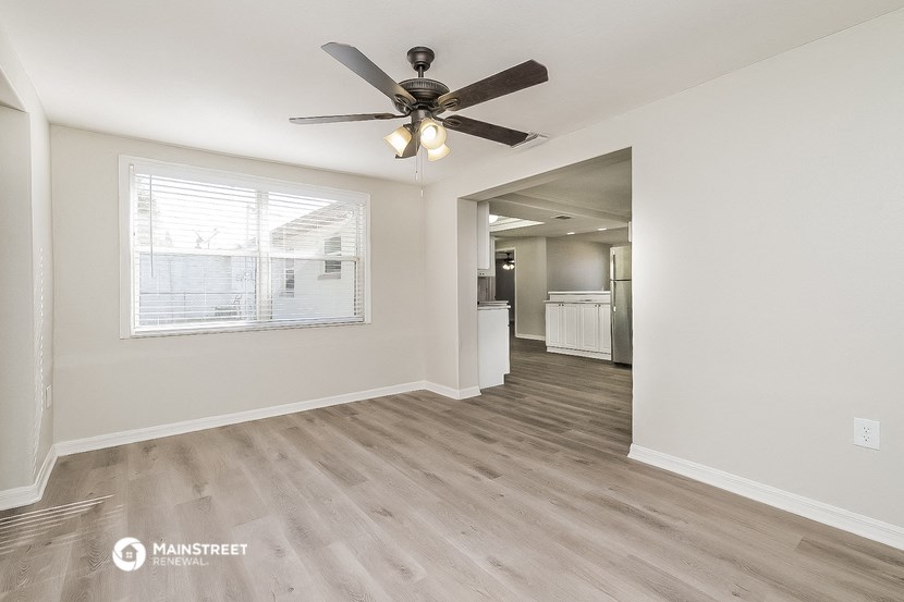 the living room and dining room with a ceiling fan