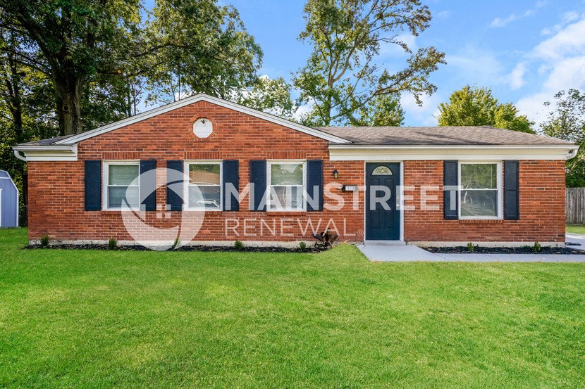 a brick house with a lawn in front