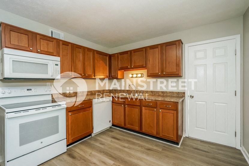 a kitchen with white appliances and wooden cabinets