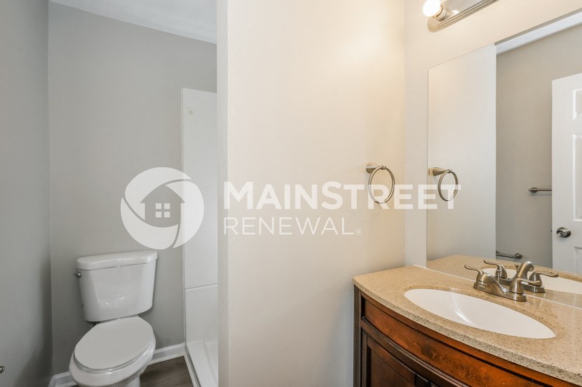 a bathroom with a toilet and a sink and a mirror