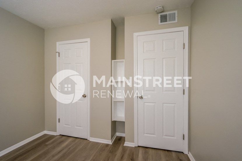 a bedroom with two doors and a closet