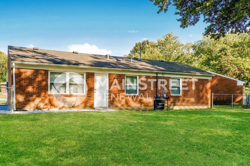 side view of a red brick house with graffiti on the side