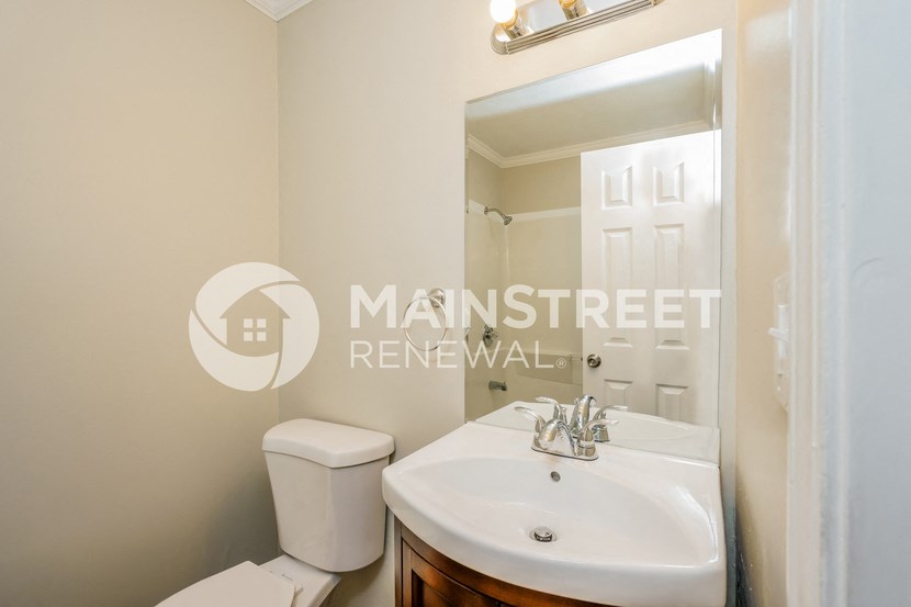 a bathroom with a toilet and a sink and a mirror