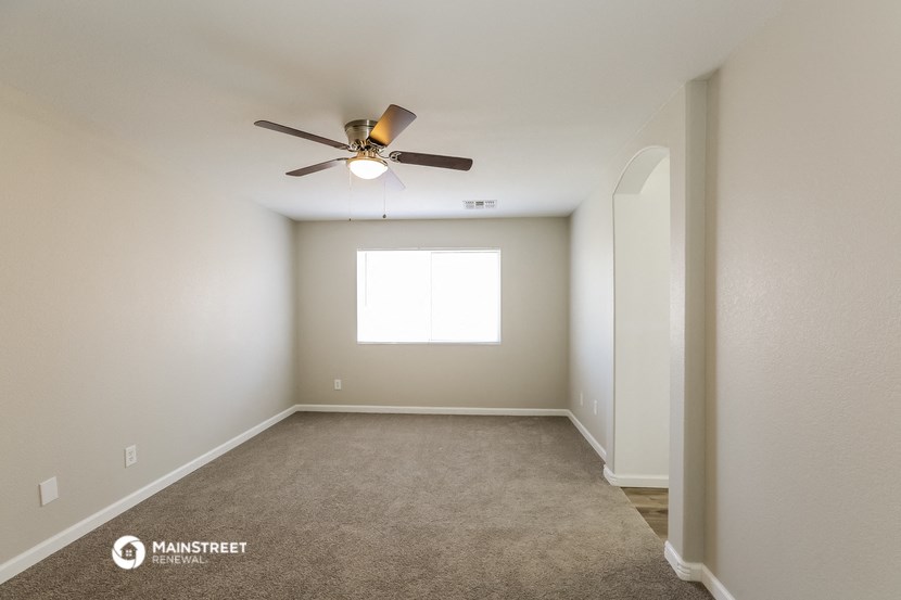 an empty room with a ceiling fan and a window