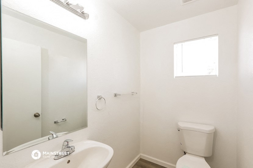 a bathroom with a toilet and a sink and a mirror