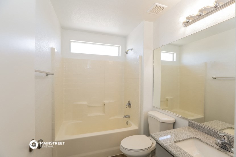 a bathroom with a shower toilet and sink and a mirror