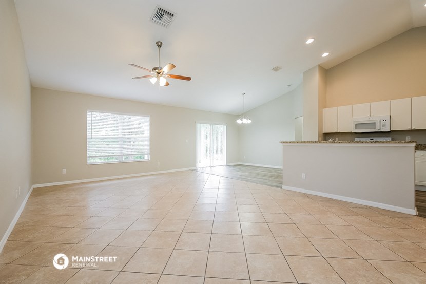 an empty kitchen and living room with a ceiling fan