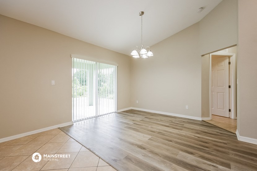 the spacious living room with a sliding glass door to the patio