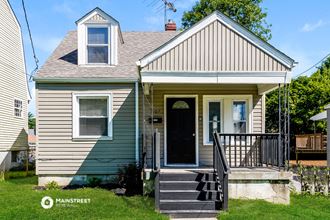 the front of a house with a porch and a black door