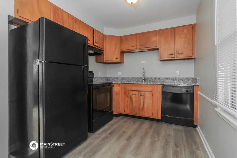 a kitchen with wood cabinets and black appliances and a black refrigerator