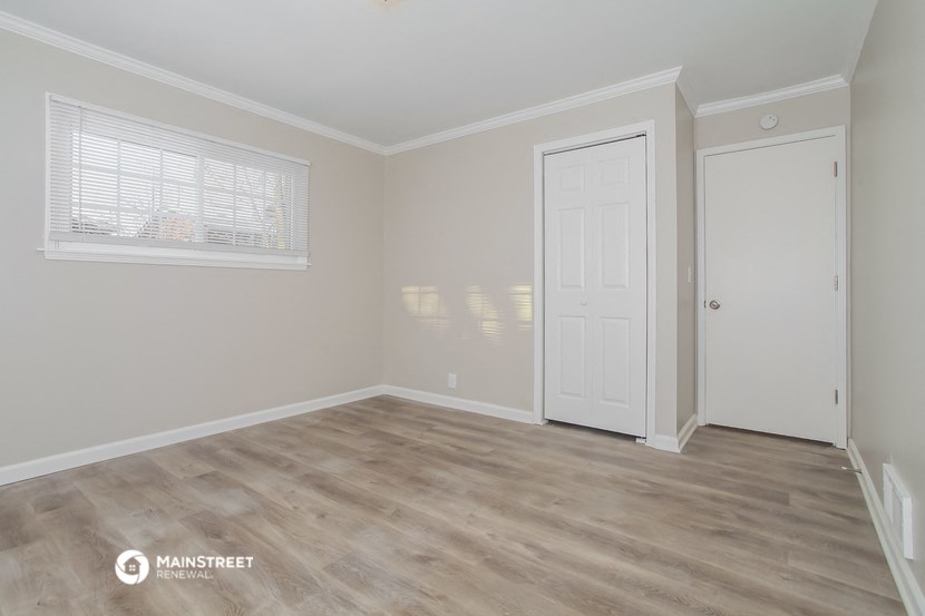 a bedroom with a white door and a door to a closet
