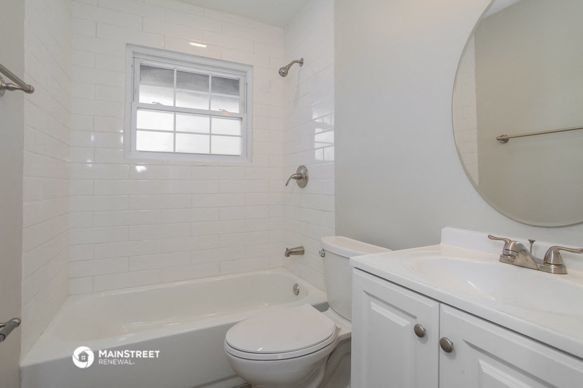 a white bathroom with a tub and a sink and a toilet