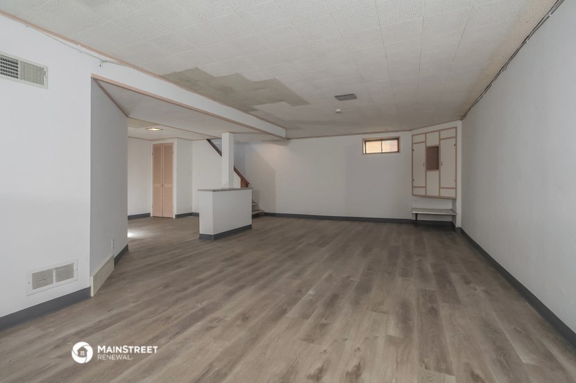 an empty living room with white walls and wood floors