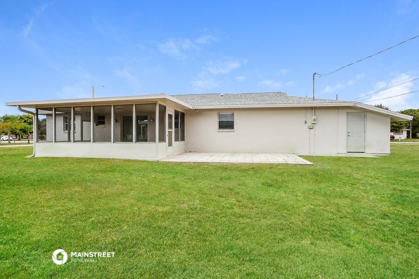 a white house with a green lawn and a blue sky