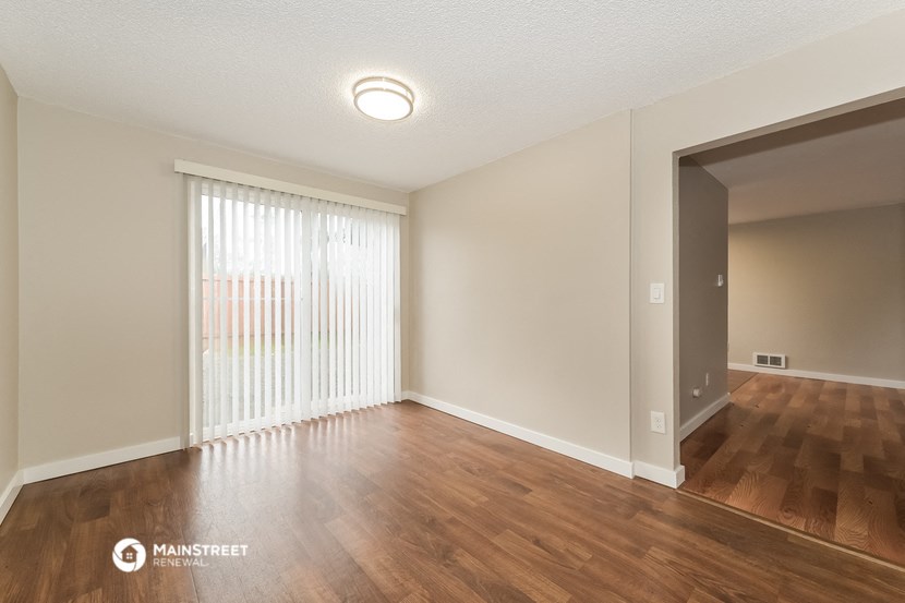 the spacious living room and dining room of an apartment