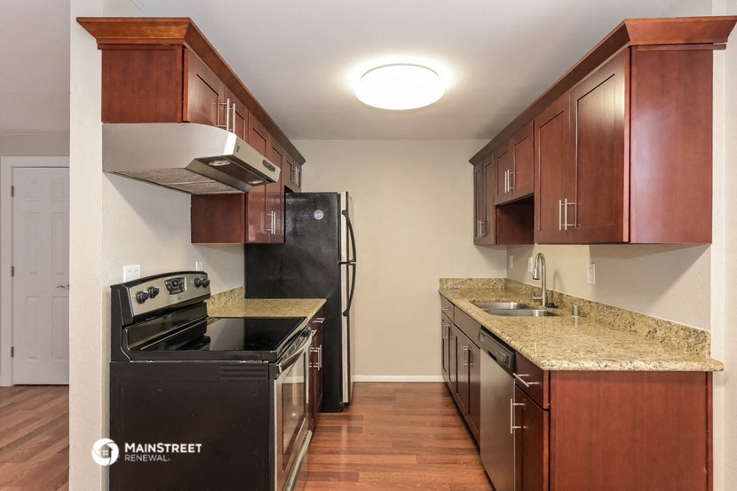 a kitchen with wood cabinets and granite counter tops and black appliances