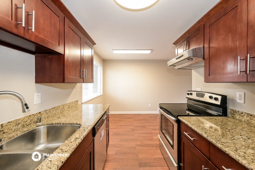 a kitchen with wood cabinets and granite counter tops and stainless steel appliances