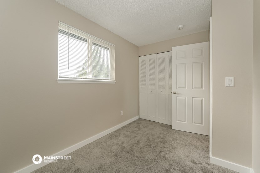 a bedroom with a closet and a door and a window