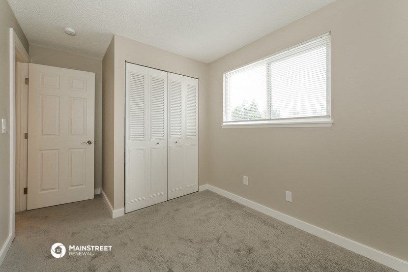 a bedroom with a closet and a window and a door