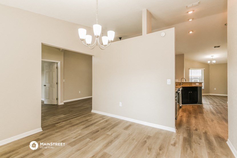 the living room and dining room with the kitchen in the background