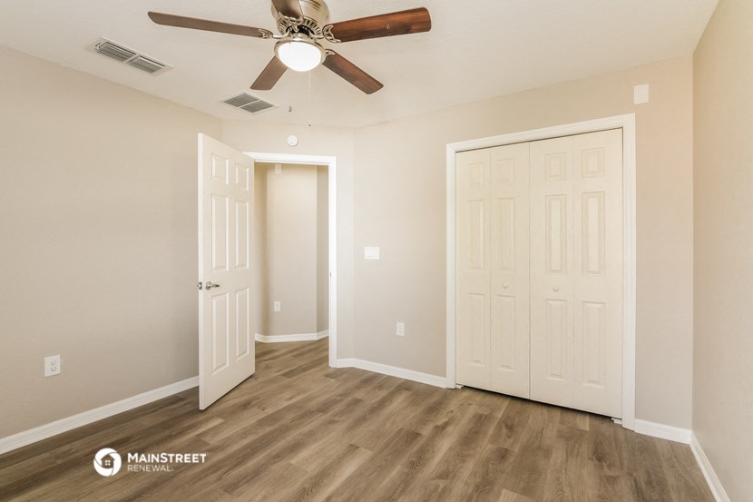 a bedroom with a ceiling fan and a closet