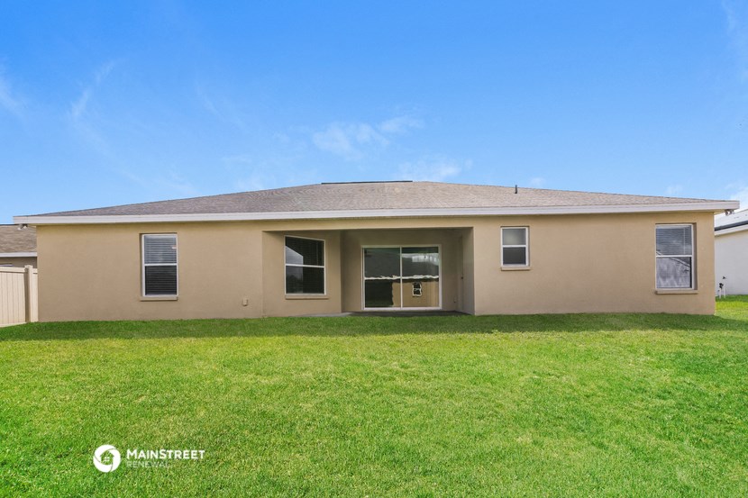 a beige house with a lawn in front of it