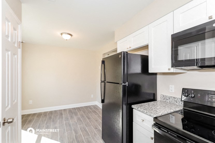 a kitchen with black appliances and white cabinets