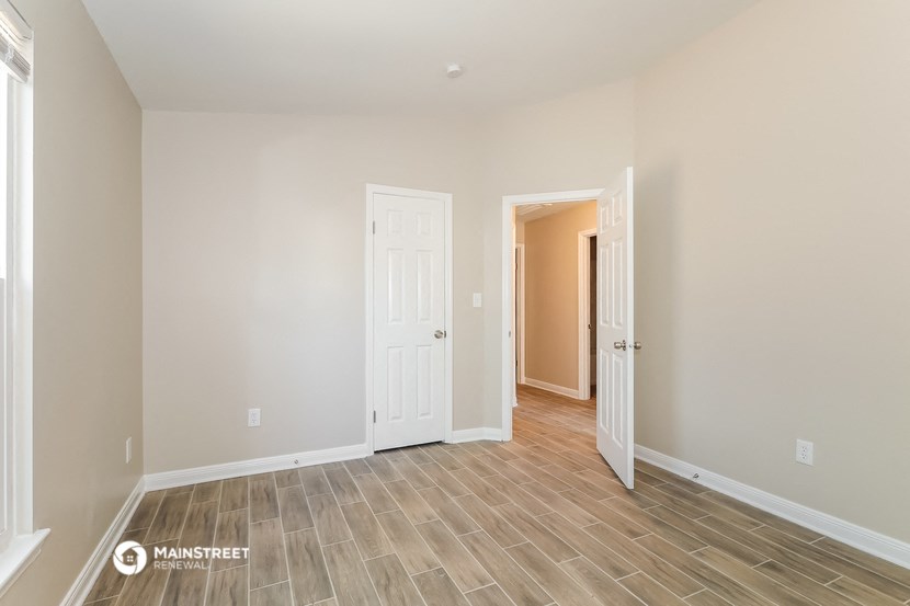 the living room and hallway of a new home with wood flooring
