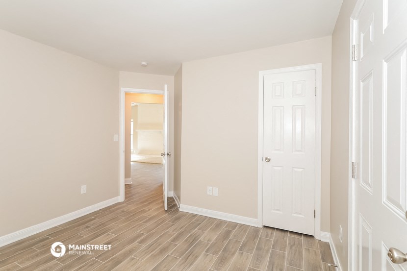 the living room and hallway of a renovated house with wood flooring