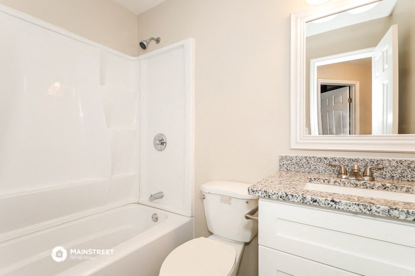 a bathroom with a toilet and a tub and a sink