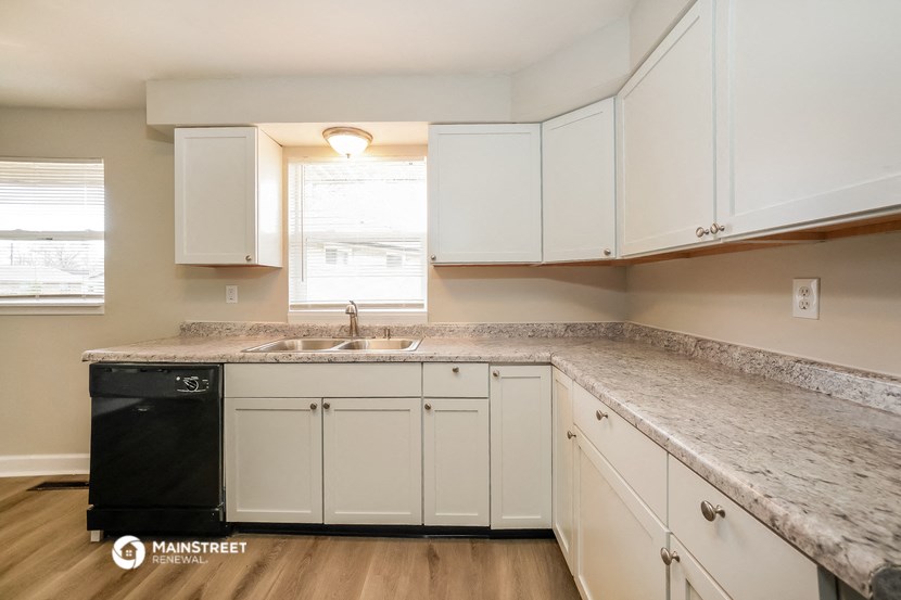 a kitchen with white cabinets and granite counter tops and a sink