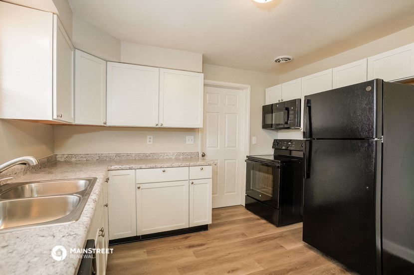 a kitchen with black appliances and white cabinets