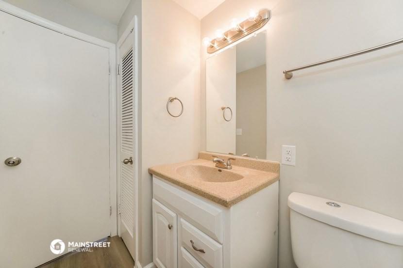 a bathroom with a toilet sink and mirror and a shower