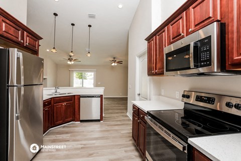 a kitchen with wooden cabinets and stainless steel appliances