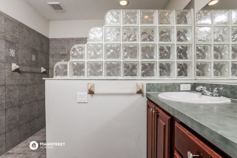 a bathroom with a sink and a glass block wall